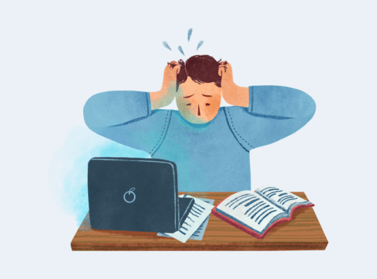 sinais de burnout no trabalho: pessoa sobrecarregada com as mãos na cabeça em frente ao computador